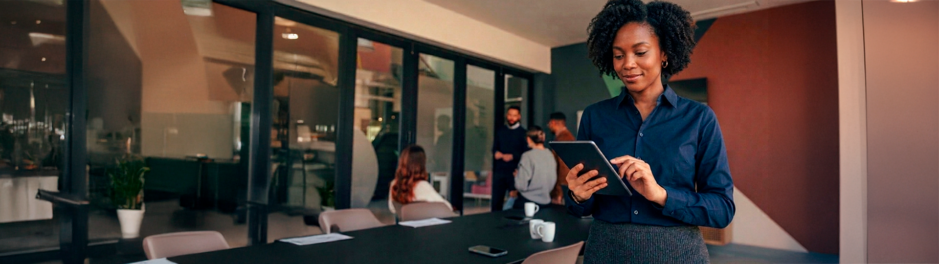 Mulher em ambiente de escritório moderno utilizando tablet para demonstrar funcionalidades avançadas de MDM em dispositivos móveis corporativos.