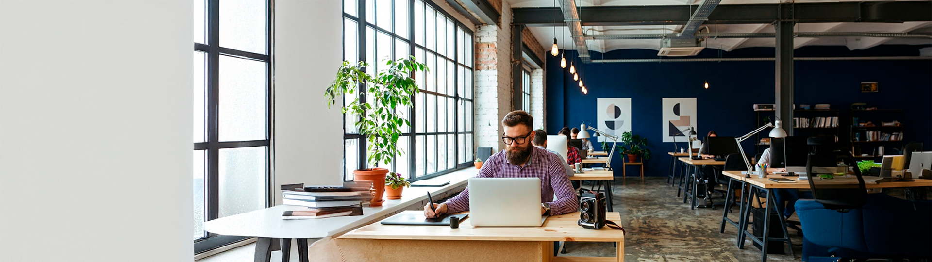 Profissional trabalhando em escritório amplo, ilustrando os riscos e o custo de não ter MDM para a gestão e segurança de dispositivos corporativos.
